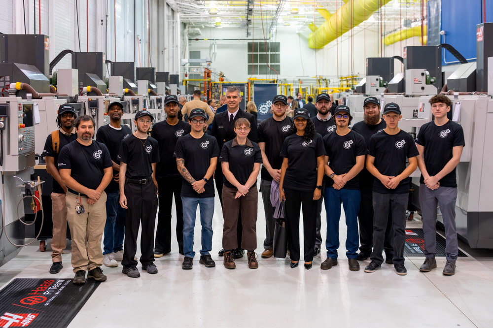 Rear Adm. Peter Small, deputy commander for Ship Design, Engineering and Logistics for Naval Sea Systems Command, poses in Macomb Community College’s maritime skilled trades training center with some of the 24 students who today began an accelerated program in either CNC or welding. 